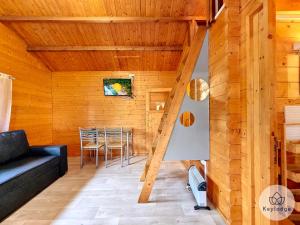 una sala de estar con una escalera en una casa de madera en Scheffléra - Bungalow aux Makes - Saint-Louis, en Saint-Louis
