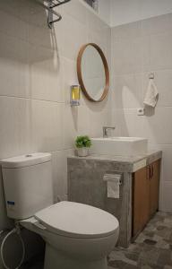y baño con aseo, lavabo y espejo. en Sastra Ubud House en Ubud