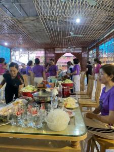a group of people standing around a table with food at Khu du Lịch Trải nghiệm Gốm Phù Lãng in Bắc Ninh