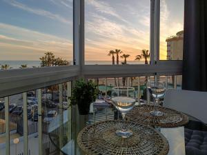 a balcony with two wine glasses on a table at Ruselo 308. Loft en paseo marítimo de Torrox Costa in Torrox Costa