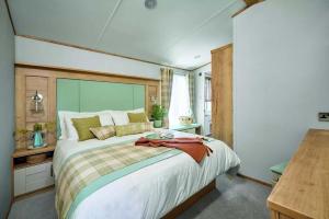 Un dormitorio con una cama grande y una mesa. en Springwood Holiday Park, en Kelso