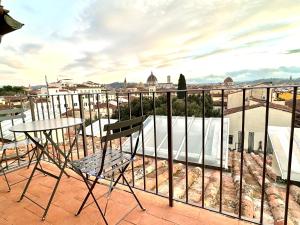 uma varanda com uma mesa e vista para a cidade em Palazzo Pandolfini's City-View Studios em Florença