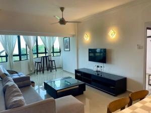 a living room with a couch and a tv at The Ferringhi Sea View at Sri Sayang in Batu Ferringhi