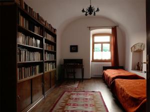 1 dormitorio con 2 camas y estanterías con libros en Úrágya Vendégház, en Mád
