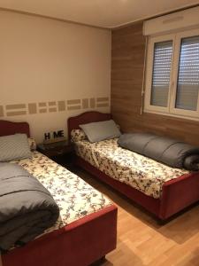 2 camas en una habitación con 2 ventanas en Le Bellagio, en Saint-Éloy-les-Mines