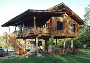 uma cabana de madeira com um alpendre e um deque em Maison autonome en bois, à Brasilito em Brasilito