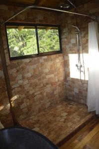 baño con ducha y ventana en Maison autonome en bois, à Brasilito, en Brasilito
