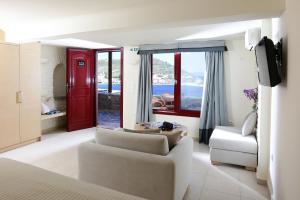 a living room with a couch and a chair at Keos Hotel in Korissia