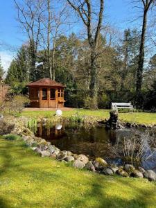 a gazebo next to a pond in a park at Landhaus Fillerberg in Wildeshausen