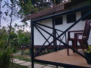 a porch of a house with a chair and a building at Oryza wayanad in Kalpetta