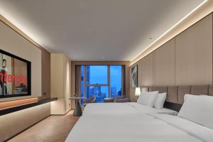 una camera d'albergo con un letto grande e una grande finestra di Hefei Huiyan Anhui Center Intercity Hotel a Hefei