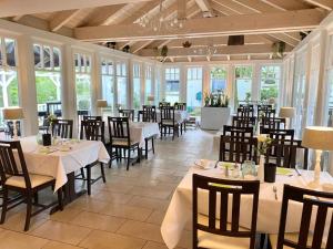 a dining room with tables and chairs and windows at Landhaus Fillerberg in Wildeshausen +27 photos