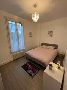 um pequeno quarto com uma cama e um lustre em Maison indépendante Chambly 3 chambres em Chambly