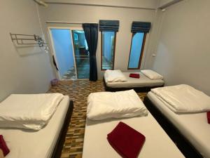 três camas num quarto com janelas em Boom Hostel Khao Sok em Parque Nacional de Khao Sok