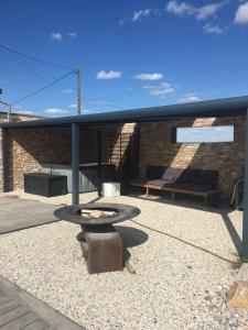 a patio with a table and a brick building at Maison 24H du Mans in Teloché