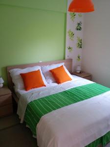 ein Bett mit zwei orangenen Kissen darüber in der Unterkunft Petalidi Beachview in Petalidi