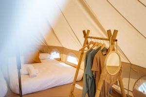 1 dormitorio en una tienda de campaña con cama y espejo en Kampaoh Playa Troenzo, en Celorio