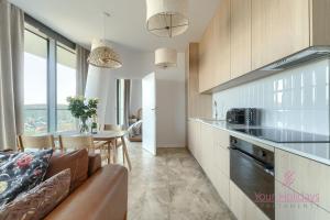 a kitchen and living room with a couch and a table at Your Holidays Waves E997 in Międzyzdroje