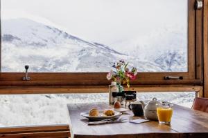 a table with a view of a snow covered mountain at Mountainhotel Saint Roch in Puy-Saint-Vincent