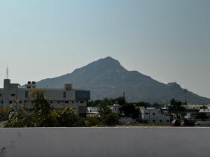 a mountain in the background of a city with buildings at JP HOME STAY in Tiruvannāmalai