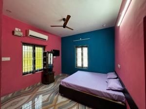 a bedroom with blue and pink walls and a bed at JP HOME STAY in Tiruvannāmalai