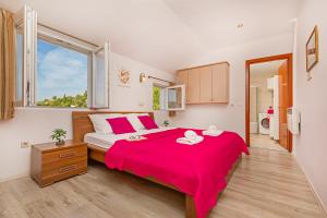 1 dormitorio con 1 cama grande con manta roja en Apartment Ive, en Mlini