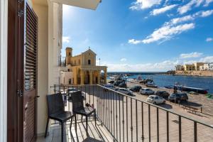 a balcony with two chairs and a view of a harbor at Balconcino sul Rivellino by BarbarHouse in Gallipoli