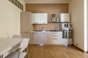 a kitchen with stainless steel appliances and wooden floors at Balconcino sul Rivellino by BarbarHouse in Gallipoli