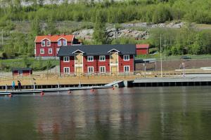 un grand bâtiment rouge à côté d'une grande étendue d'eau dans l'établissement Örnsköldsviks Gästhamn, à Örnsköldsvik