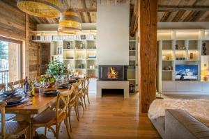 a dining room with a long table and a fireplace at Chalet Backflip - OVO Network in La Clusaz