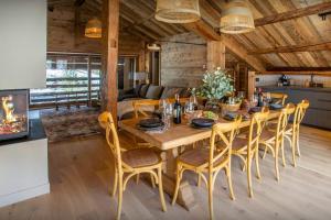 Un comedor con mesa y sillas de madera. en Chalet Backflip - OVO Network, en La Clusaz