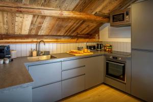a kitchen with white appliances and wooden ceilings at Chalet Backflip - OVO Network in La Clusaz +29 photos