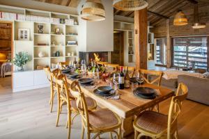 a dining room with a wooden table and chairs at Chalet Backflip - OVO Network in La Clusaz