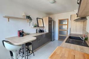 a kitchen with a counter and a refrigerator at Le Salin - Terrasse - Parking - Wifi in Clermont-Ferrand
