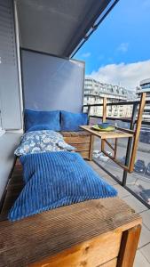 un balcone con un letto e un tavolo su una nave di Le Salin - Terrasse - Parking - Wifi a Clermont-Ferrand