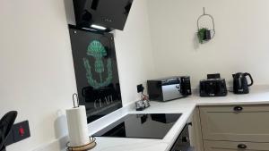 a kitchen with a counter top with a sink and a microwave at Braeview, Contemporary Luxury NC500 Holiday Home - Sleeps 5 in Wick