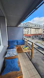 een balkon met blauwe stoelen en een tafel in een gebouw bij Le Salin - Terrasse - Parking - Wifi in Clermont-Ferrand
