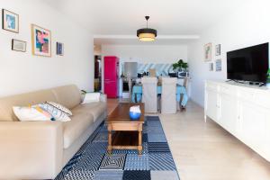 a living room with a couch and a tv at A3 - 2 BDR Sea View 10 min Beach - Parking, Pool & Terrace in Antibes
