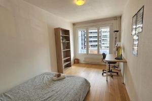 una camera da letto con un letto, una scrivania e una finestra di Le Salin - Terrasse - Parking - Wifi a Clermont-Ferrand