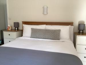 1 dormitorio con 1 cama blanca grande y 2 mesitas de noche en Cherry Tree Cottage in idyllic Cotswold village, en Chipping Norton