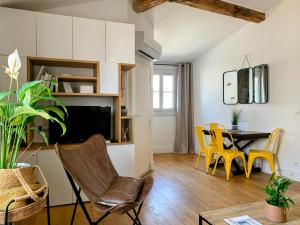 a living room with a dining room table and yellow chairs at Home Chic Home - Les Toits de Sainte-Ursule in Montpellier