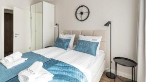 Schlafzimmer mit einem Bett mit blauen und weißen Kissen in der Unterkunft Lion Apartments - SCALA City Center Apartments&Studio IIA in Danzig