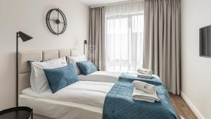 a bedroom with a large bed with blue pillows at Lion Apartments - SCALA City Center Apartments&Studio IIA in Gdańsk