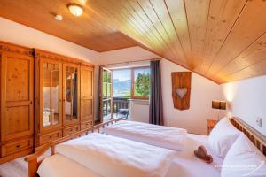 a bedroom with two beds and a large window at Hartungs Hoteldorf in Füssen +91 photos