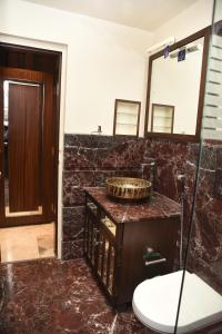 een badkamer met een wastafel en een spiegel bij BelAir Suites Pune in Pune