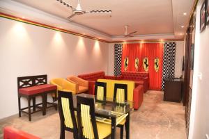 a waiting room with red and yellow chairs and tables at BelAir Suites Pune in Pune