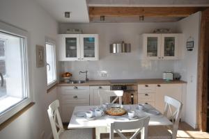 a kitchen with a white table and chairs and a table and chairsktop at Hoheluft am Wittensee Apt 1 in Groß Wittensee