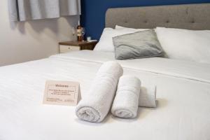 dwa składane ręczniki na łóżku z napisem w obiekcie GODSON TALPIOT w mieście Hajfa