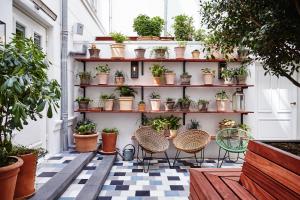 eine Terrasse mit Stühlen und Topfpflanzen auf Regalen in der Unterkunft The Hoxton, Amsterdam in Amsterdam