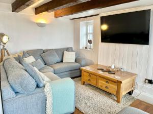 sala de estar con sofá y TV en Harbourside, en Staithes
